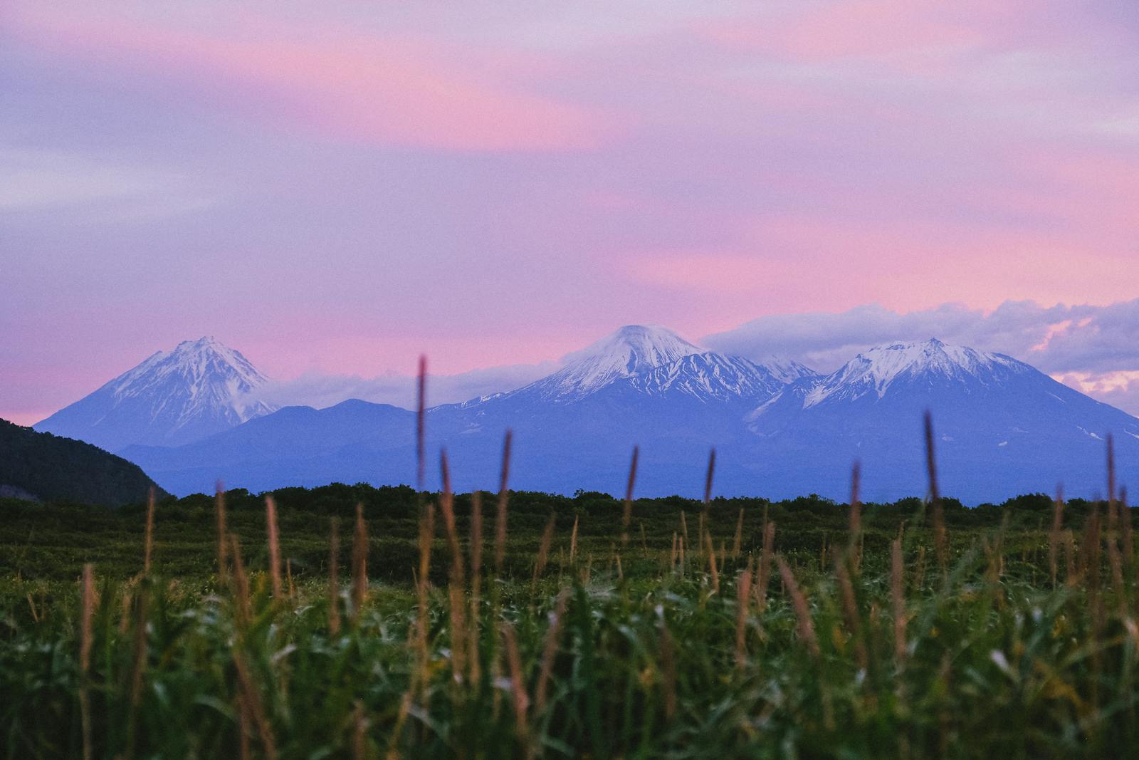 Enchanting sunset view of the snow-capped volcanoes in Kamchatka, Russia.